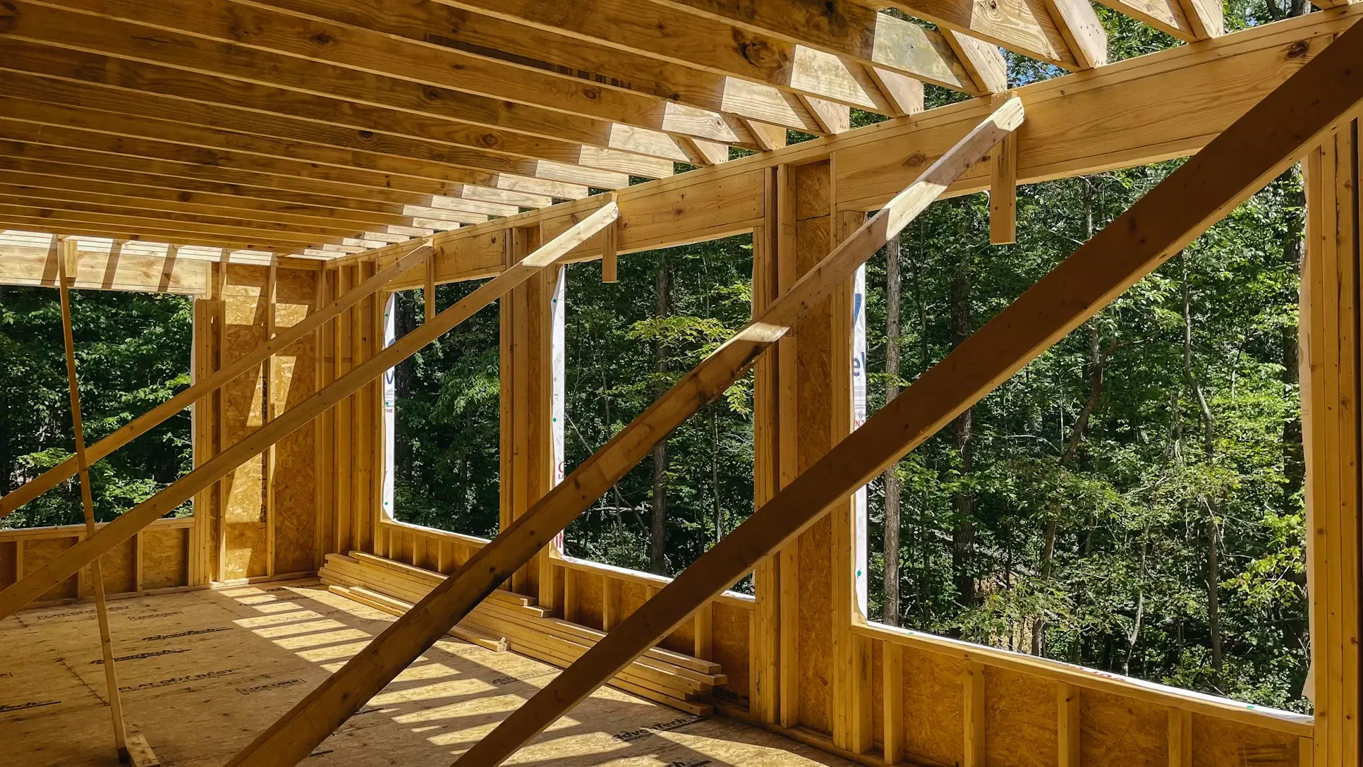 New home addition framed and under construction, surrounded by trees